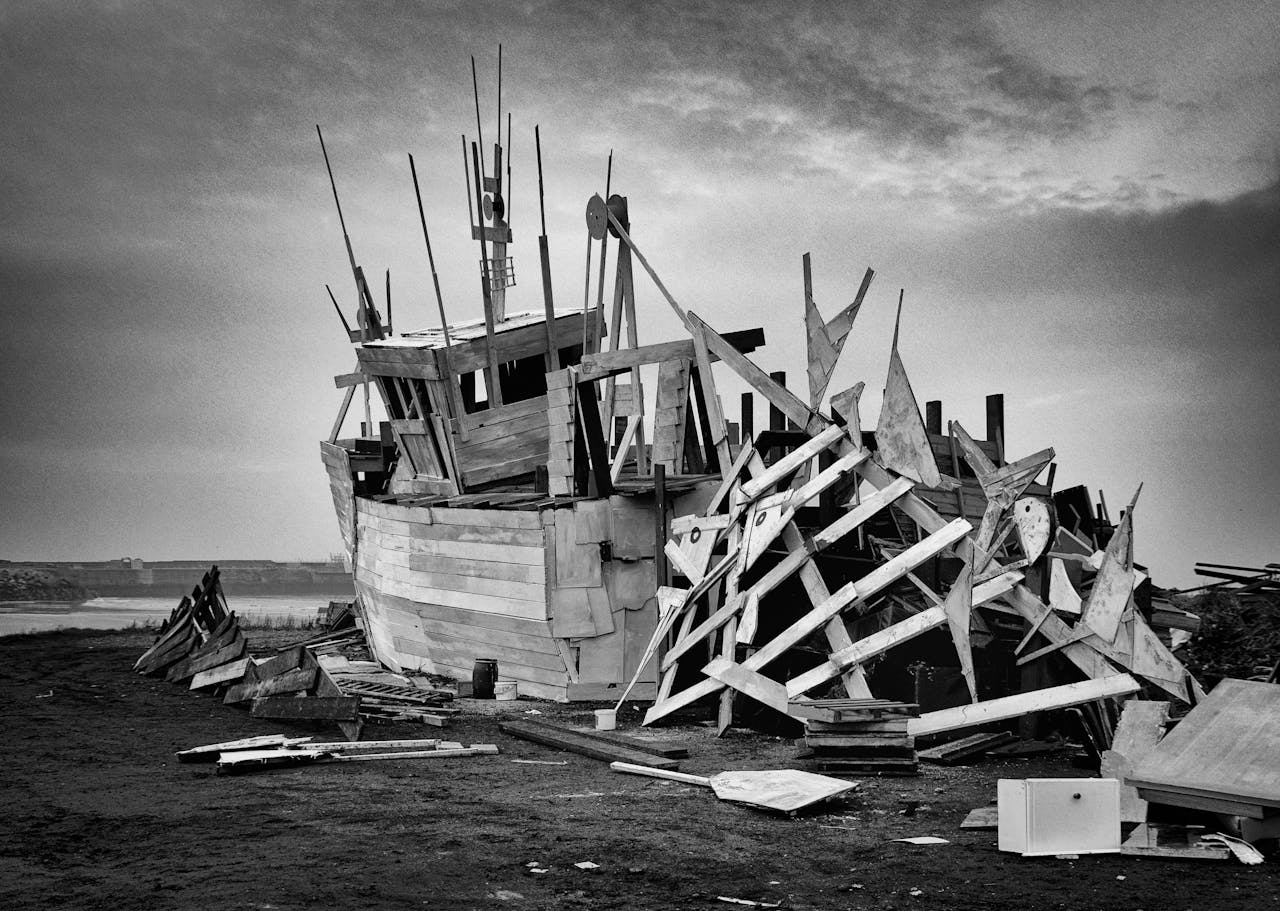 Dramatic black and white image of a shipwreck on a coastal shore, capturing maritime wreckage.